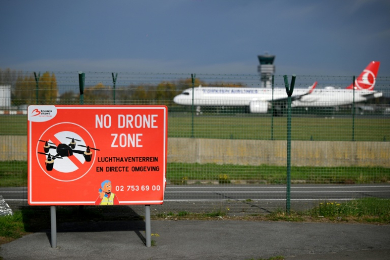 Un panneau "Zone interdite aux drones" alors qu'un avion atterrit à l'aéroport de Bruxelles-Zaventem, le 5 novembre 2025 ( AFP / Nicolas TUCAT )