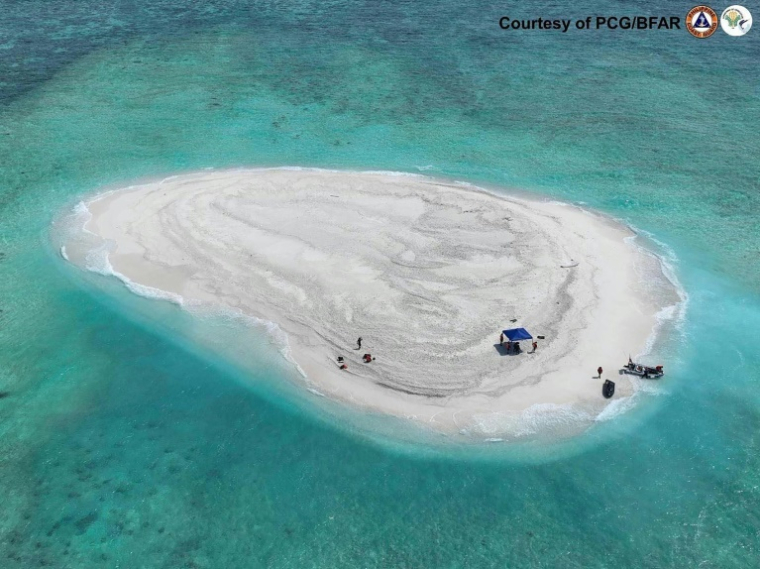 Photo diffusée le 21 mars 2024 par la Garde côtière philippine et le Bureau de la pêche et des ressources aquatiques (PCG/BFAR) montrant une vue aérienne de scientifiques philippins inspectant le récif de Sandy Cay, dans les îles Spratley, en mer de Chine méridionale ( Philippine Coast Guard (PCG) / Handout )