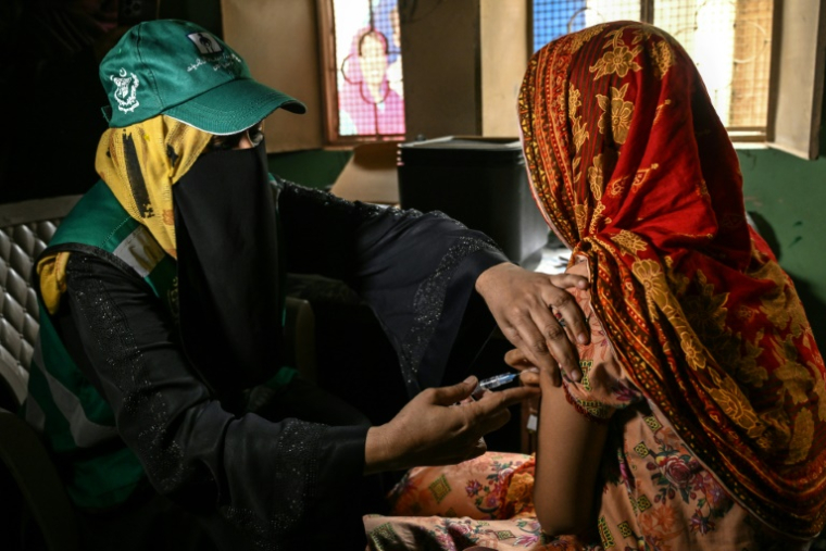 Une soignante (g) administre le vaccin contre le virus du papillome humain (VPH) à une adolescente, lors d'une campagne de vaccination contre le cancer du col de l'utérus, le 24 septembre 2025 à Karachi, au Pakistan ( AFP / Rizwan TABASSUM )