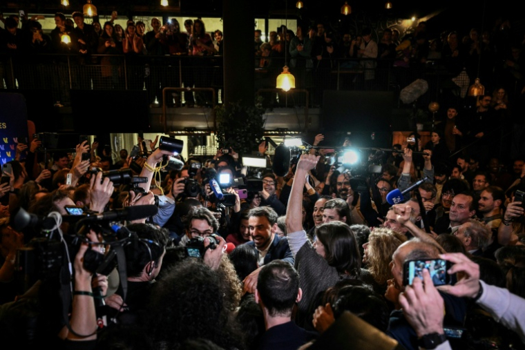 Le maire écologiste sortant de Lyon et candidat à sa réélection, Grégory Doucet (c), célèbre sa victoire au 2e tour des municipales, le 22 mars 2026 à Lyon, dans le Rhône ( AFP / JEFF PACHOUD )