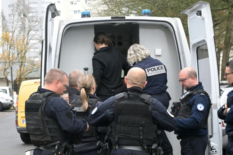 Une jeune femme soupçonnée de trafic de stupéfiants est arrêtée et placée dans un fourgon de police lors d'une opération de sécurité dans un quartier de Nantes, le 17 décembre 2025 ( AFP / Damien MEYER )