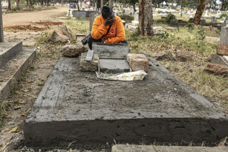 Catherine pleure près de la tombe fraîchement bétonnée de son amie Judy, une travailleuse du sexe kenyane séropositive décédée d’une maladie liée au sida, au cimetière de Langata à Nairobi, le 8 septembre 2026 ( AFP / SIMON MAINA )