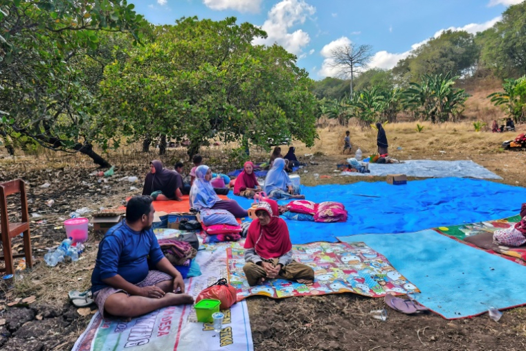 Des habitants ont passé la nuit dehors après le puissant séisme qui a secoué l'île indonésienne de Florès, dans l'est de l'archipel, le 16 août 2026 à Sikka, dans la province de Nusa Tenggara Est ( AFP / ARNOLD WELIANTO )