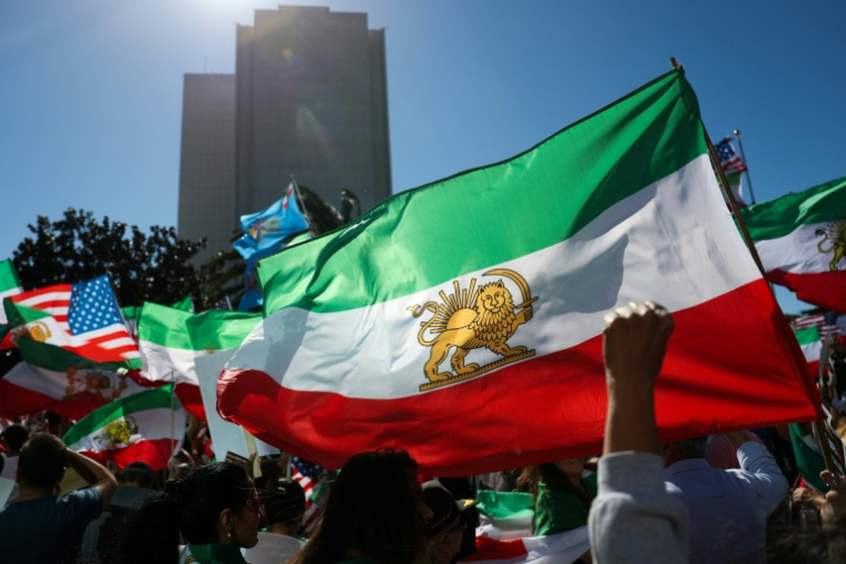 Des manifestants brandissent des drapeaux iraniens datant d'avant la Révolution islamique, lors d'une manifestation à Los Angeles, le 7 mars 2026 ( AFP / Patrick T. Fallon )