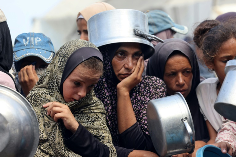Des Palestiniens attendent une distribution de repas à Khan Younès, dans le sud de la bande de Gaza, le 21 août 2025 ( AFP / - )