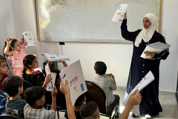 Hadeel Zourob, une enseignante palestinienne déplacée par la guerre à Gaza, lors d'un cours à des enfants également déplacés à Al-Arish, dans le nord de l'Egypte, le 1er octobre 2026  ( AFP / Amr AHMED )