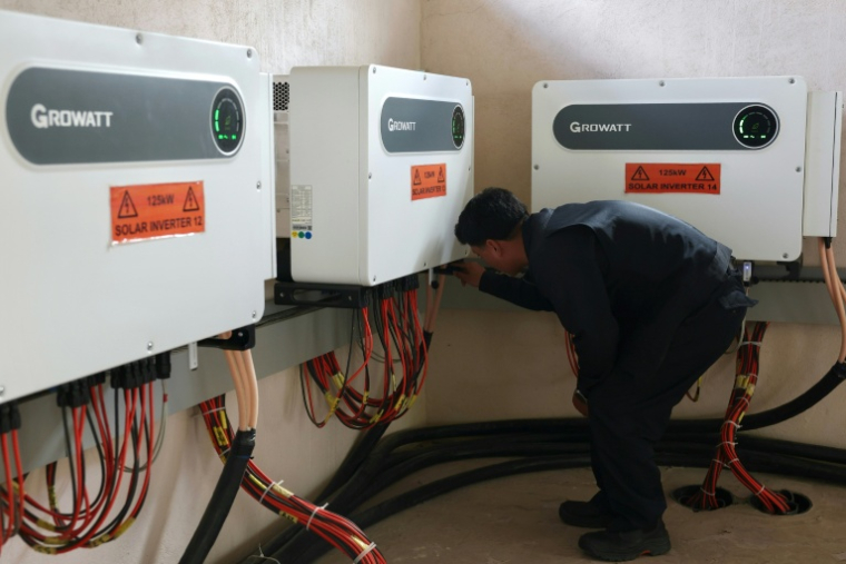L'ingénieur principal Rinzin Galley contrôlant des onduleurs solaires dans une salle de contrôle du site de l’entreprise Norion Renewable Energy, dans la capitale bhoutanaise, Thimphou, le 30 août 2026 ( AFP / Niharika KULKARNI )