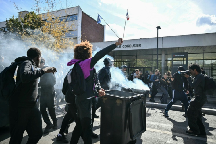 Des lycéens poussent une poubelle en feu devant le lycée Le Corbusier bloqué à Aubervilliers, en Seine-Saint-Denis, le 1er octobre 2026 ( AFP / LOU BENOIST )