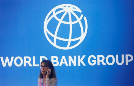 Photo d'archives d'une personne devant le logo de la Banque mondiale à Nusa Dua, Bali, Indonésie