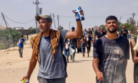 Un Palestinien montre un paquet reçu à un point de distribution d'aide humanitaire dans la région de  Rafah, dans le sud de la bande de Gaza, le 28 juillet 2025 ( AFP / - )