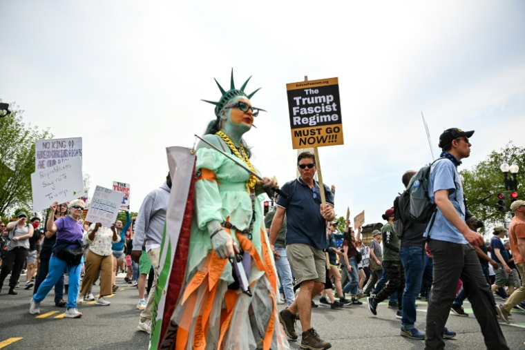 Des manifestants brandissent des pancartes en marchant vers la Maison Blanche lors d'une manifestation pour la libération du Salvadorien expulsé à tort Kilmar Abrego et contre Donald Trump, à Washington, le 19 avril 2025 ( AFP / Richard PIERRIN )