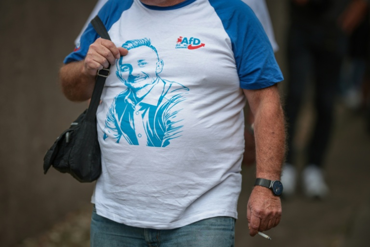 Un participant portant un tee-shirt à l'effigie d'Ulrich Siegmund, principal candidat du parti d'extrême droite AfD aux élections régionales de Saxe-Anhalt, arrive à un meeting électoral à Haldensleben (est de l'Allemagne), le 1er septembre 2026 ( AFP / Ronny HARTMANN )