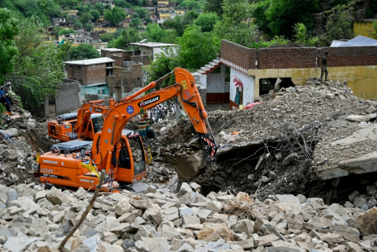 Des secouristes utilisent des pelleteuses pour dégager les décombres des maisons effondrées et rechercher des victimes dans les débris, à Dalori, dans la province montagneuse de Khyber Pakhtunkhwa, le 19 août 2025 au Pakistan ( AFP / Aamir QURESHI )