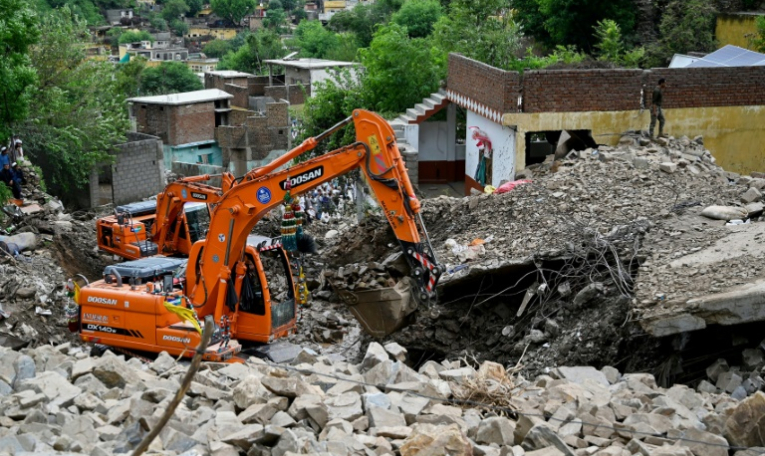 Des secouristes utilisent des pelleteuses pour dégager les décombres des maisons effondrées et rechercher des victimes dans les débris, à Dalori, dans la province montagneuse de Khyber Pakhtunkhwa, le 19 août 2025 au Pakistan ( AFP / Aamir QURESHI )