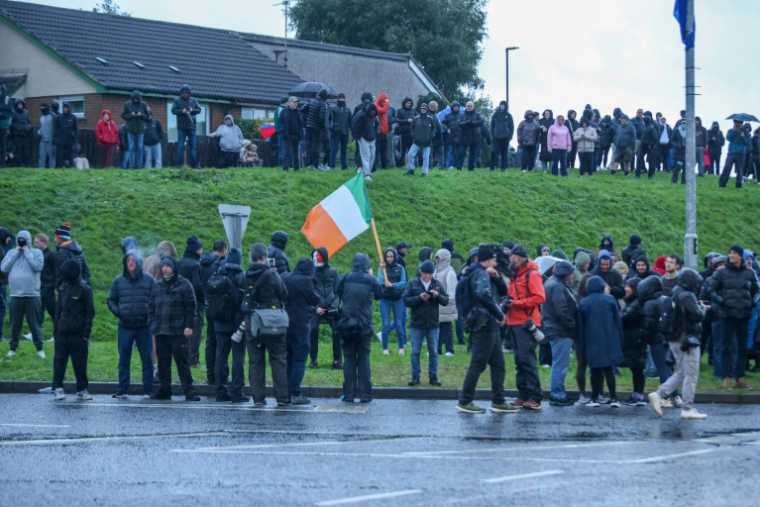 Des manifestants rassemblés à Portadown, en Irlande du Nord, contre le passage d'une marche protestante pro-britannique autorisée pour la première fois depuis 1997 en plein quartier catholique, le 27 septembre 2026  ( AFP / Paul Faith )