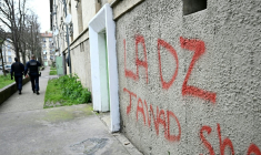 Des policiers patrouillent à proximité d'un mur avec un tag DZ désignant la DZ mafia à Avignon le 13 mars 2025 ( AFP / GABRIEL BOUYS )