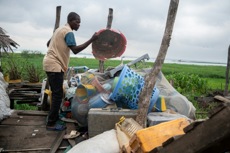 Un pêcheur jettent des déchets plastiques qu'il a ramassés en bateau près du fleuve Congo, sur l'île de Kimpoko, à Kinshasa, le 27 avril 2026 en RDC ( AFP / Hardy BOPE )