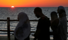 Le soleil se couche sur la mer Méditerranée alors que des Palestiniens déplacés évacuent la ville de Gaza vers le sud de la bande de Gaza face aux bombardements israéliens, le 13 septembre 2025 dans la bande de Gaza ( AFP / Eyad BABA )