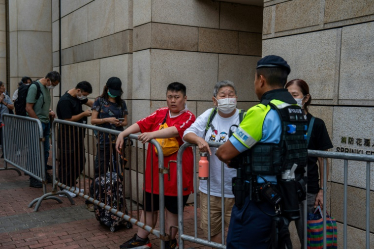 Des personnes attendent devant le tribunal de West Kowloon où se déroule le procès du magnat des médias Jimmy Lai, le 28 août 2025 à Hong Kong ( AFP / Vernon Yuen )