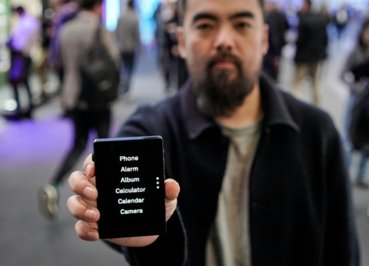 Le directeur général de l'entreprise Light Phone, Kaiwei Tang, présente un Light Phone III au Salon du mobile à Barcelone le 3 mars 2026, en Espagne ( AFP / Manaure Quintero )
