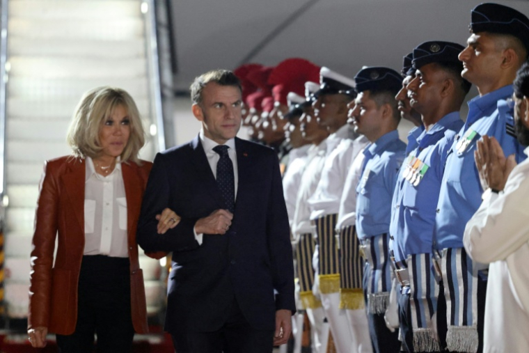 Le président français Emmanuel Macron (au centre à d.) et son épouse Brigitte Macron (à g.) sont accueillis par des responsables indiens à leur arrivée à Bombay, en Inde, le 17 février 2026 ( AFP / Ludovic MARIN )