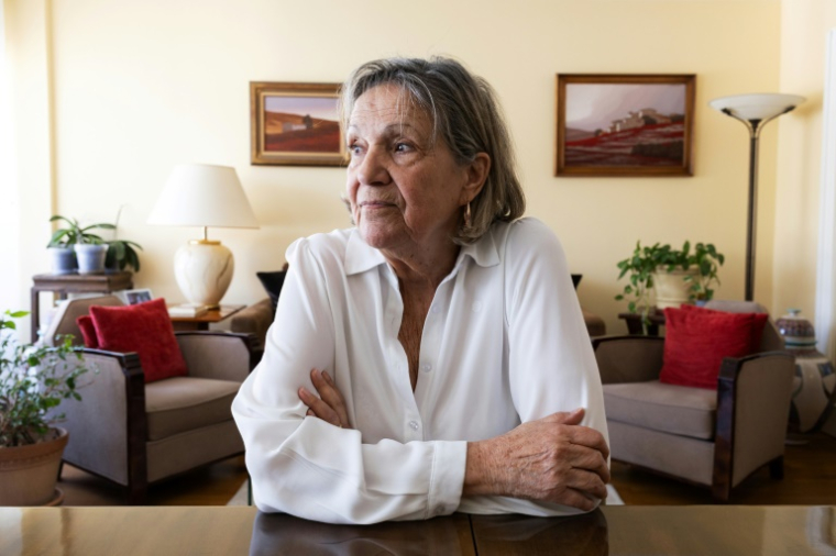 Claudine Spire regarde une photo de son enfance lors d'une interview à son domicile de Chaville, en région parisienne, le 9 avril 2025 ( AFP / Xavier GALIANA )
