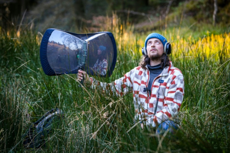 L'ornithologue irlandais Sean Ronayne enregistre des chants d'oiseaux, près de Cobh, le 3 avril 2025 ( AFP / Paul Faith )