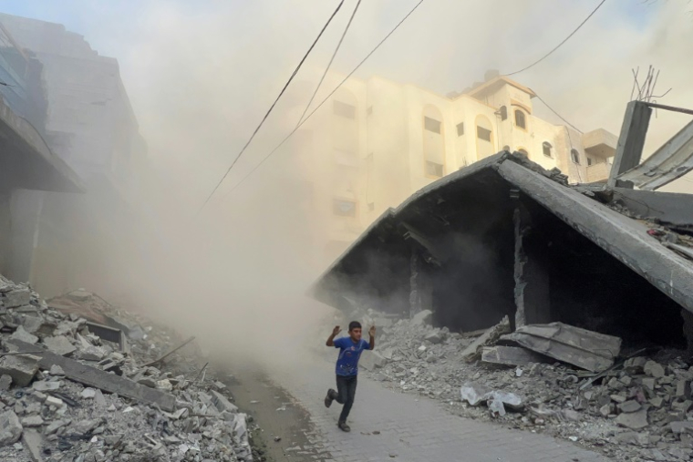 Un garçon palestinien fuit en courant des frappes aériennes à Jabalia, dans le nord de la bande de Gaza, le 19 août 2025 ( AFP / Bashar TALEB )