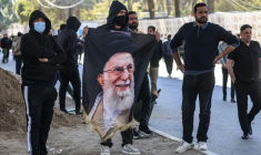 Des manifestants irakiens, dont l’un tient un portrait du guide suprême iranien assassiné, Ali Khamenei, se tiennent près de la Zone verte, où se trouve l’ambassade des États-Unis, à Bagdad, le 1er mars 2026. ( AFP / Ahmad AL-RUBAYE )
