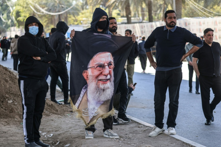 Des manifestants irakiens, dont l’un tient un portrait du guide suprême iranien assassiné, Ali Khamenei, se tiennent près de la Zone verte, où se trouve l’ambassade des États-Unis, à Bagdad, le 1er mars 2026. ( AFP / Ahmad AL-RUBAYE )