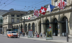 Des passants défilent devant un véhicule de police stationné devant la gare centrale de Winterthur, près de Zurich, où un homme a blessé trois personnes à l'arme blanche le 28 mai 2026 ( AFP / ARND WIEGMANN )