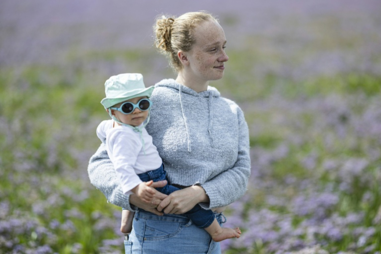 Lou-Anne pose avec son bébé de 11 mois au Crotoy, dans la baie de Somme, le 30 juillet 2025 ( AFP / Sameer Al-DOUMY )