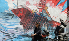 Une femme passe devant une fresque anti-américaine et anti-israélienne à Téhéran, le 10 mai 2026. ( AFP / ATTA KENARE )
