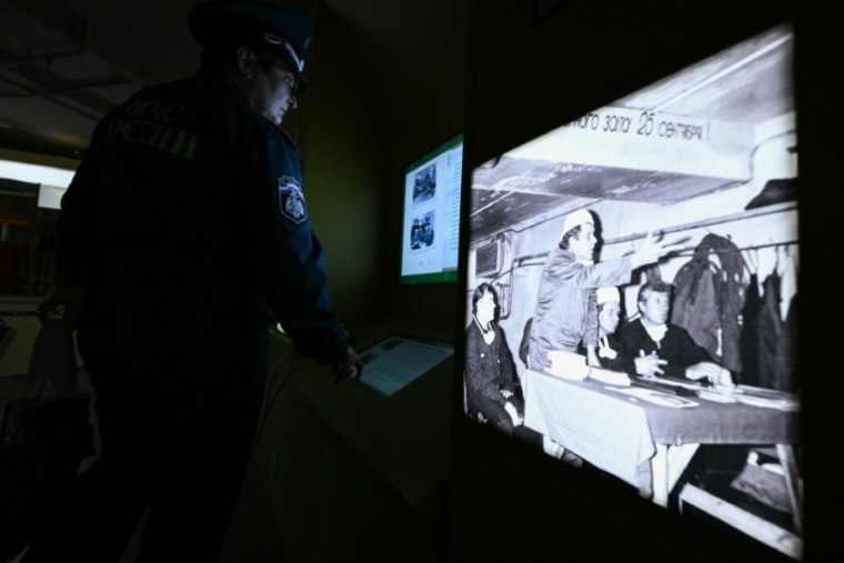 Un employé des services d'urgence ukrainiens consulte des informations sur l'accident de la centrale nucléaire de Tchernobyl, le 24 avril 2026 à Moscou, lors d'une exposition temporaire consacrée au 40e anniversaire de la catastrophe ( AFP / Igor IVANKO )