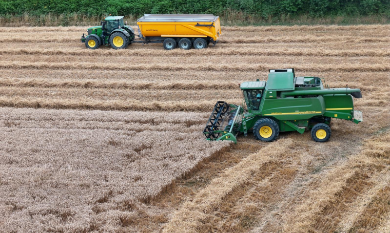 Cette photographie montre une moissonneuse-batteuse et un tracteur dans un champ de blé à Hede-Bazouges, dans l'ouest de la France, le 18 juillet 2025. ( AFP / DAMIEN MEYER )