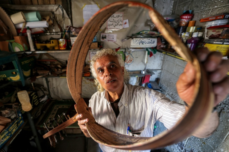 Le luthier palestinien Souhail Abou Chawich dans son atelier de réparation d'ouds, au camp de réfugiés de Nousseirat, dans le centre de la bande de Gaza, le 23 juin 2026 ( AFP / Eyad Baba )