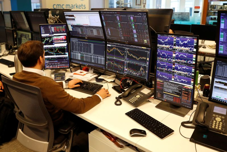 Un trader travaille à son bureau chez CMC Markets dans la City de Londres