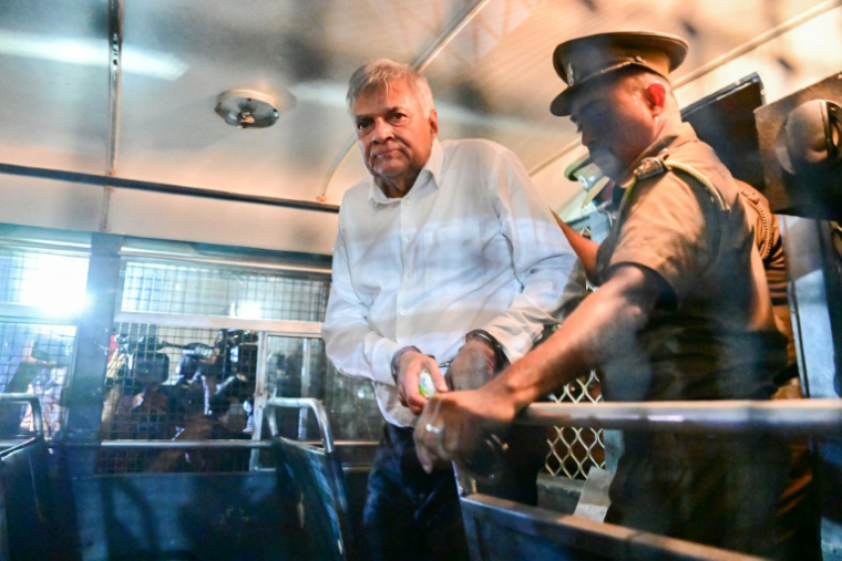 L'ancien président du Sri Lanka, Ranil Wickremesinghe, est escorté jusqu'à son siège dans un bus pénitentiaire à Colombo le 22 août 2025, après avoir été placé en détention provisoire suite à des allégations de détournement de fonds publics ( AFP / Ishara S. KODIKARA )