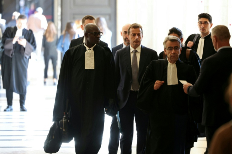 Guillaume Faury (au centre), PDG d'Airbus, arrive avec ses avocats à la cour d'appel pour le procès en appel d'Airbus et d'Air France pour « homicide involontaire » dans le crash du vol A330 d'Air France Rio-Paris, à Paris le 29 septembre 2025 ( AFP / Alain JOCARD )