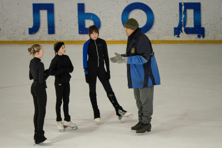 L'entraîneur ukrainien Oleksandre Toumanovsky parle avec trois jeunes patineuses, à Kiev, le 16 octobre 2026  ( AFP / Genya SAVILOV )