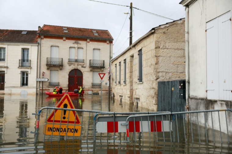 Des sauveteurs en barque dans une rue inondée après la crue de la Charente à Saintes, le 18 février 2026 en Charente-Maritime ( AFP / ROMAIN PERROCHEAU )