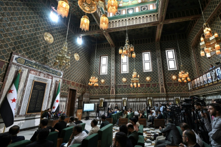 Le président de la Haute commission électorale Mohammad Taha al-Ahmad (g)  lors d'une conférence de presse annonçant la nomination de nouveaux députés au Parlement, le 1er juillet 2026 de Damas, en Syrie ( AFP / LOUAI BESHARA )