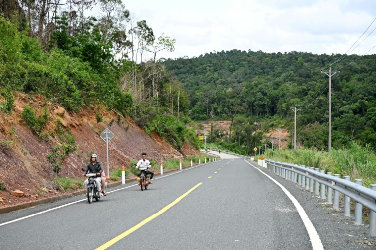 Des motocyclistes sur une route du parc national des Cardamomes, dans la province de Koh Kong, le 11 juin 2026 au Cambodge ( AFP / TANG CHHIN Sothy )