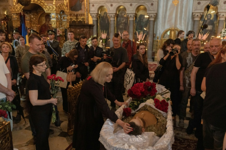 Des proches et des amis pleurent près du cercueil d'Oleksiï Ioukov, chef de l'unité de recherche ukrainienne Platsdarm, lors de ses funérailles à Kiev, le 8 août 2026 ( AFP / Roman PILIPEY )