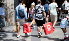 Des passants portent des sacs de courses à Paris, le 25 juin 2025, premier jour des soldes d'été en France ( AFP / Emma DA SILVA )