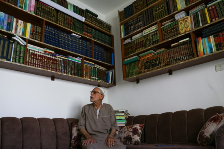 Mustafa Khaled Alwan devant sa bibliothèque, à son domicile à Homs, en Syrie, le 19 septembre 2026 ( AFP / Bakr ALKASEM )