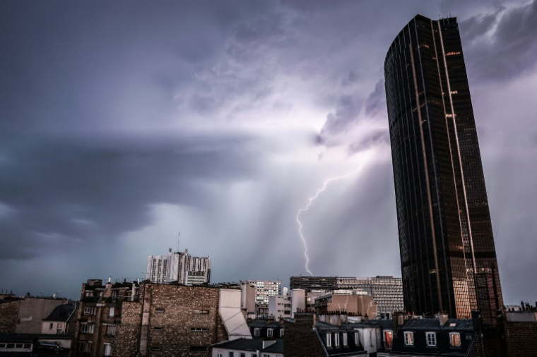 Un éclair dans un ciel d'orage près de la Tour Montparnasse à Paris, le 25 juin 2025 ( AFP / Thibaud MORITZ )