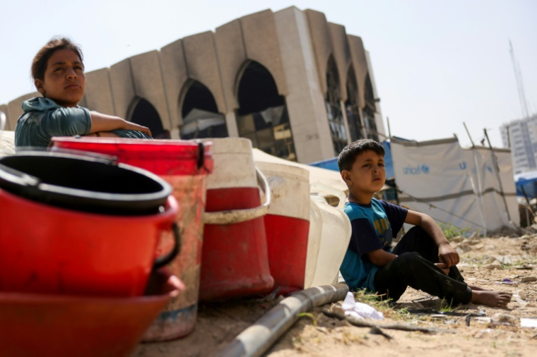 Des habitants déplacés de Gaza à un point de collecte d'eau, dans la ville de Gaza, dans le nord du territoire palestinien, le 20 mai 2025 ( AFP / Bashar TALEB )