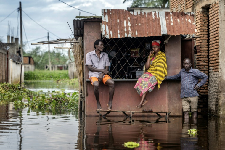 Des habitants sont rassemblés devant un kiosque inondé à Gatumba, au Burundi, le 9 mai 2025 ( AFP / Luis TATO )