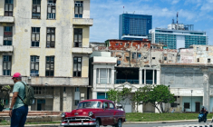 Un homme marche dans la rue tandis qu'une voiture classique passe, avec en arrière-plan l'hôtel Iberostar Selection et l'hôtel Habana Libre Melia, à La Havane, le 2 juin 2026 ( AFP / ADALBERTO ROQUE )
